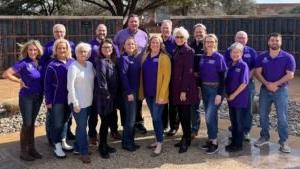 Members of the alumni association stand and smile.